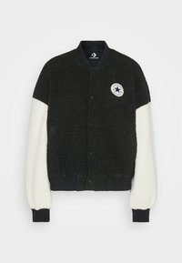 Svart och gräddfärgad fleece bomberjacka med ribbade muddar och nederkant, med en rund Converse-logotyp på vänster bröst. Mjuk textur, knappstängning.