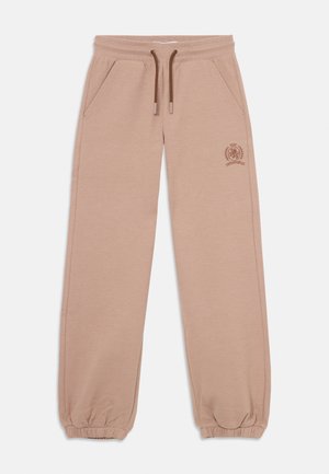 Pantalones de chándal de algodón beige con dos bolsillos laterales, cintura elástica, cordón y puños, con un logo marrón en el muslo izquierdo.