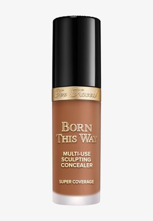 Too Faced Born This Way multi-use sculpting concealer bottle with black cap and gold detailing, shade medium brown.