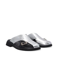 Metallic sølv sandaler med glidesål og struktureret overflade, med en sort sål og dekorative spænde detaljer på den øverste del.