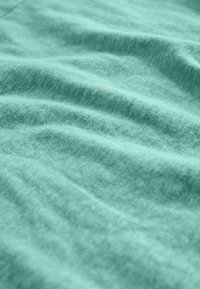 Ľahká tyrkysová textília s jemným, štruktúrovaným povrchom, zobrazujúca jemné vlny a mierne kefovaný vzhľad, ideálna pre rôzne použitie.