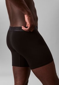 Czarne slipy wykonane z gładkiego materiału o dopasowanym kroju z miękkim, elastycznym pasem w talii z logo.