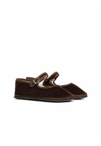 Bruine suède pantoffels met een spitse neus, voorzien van twee verstelbare banden en beige accenten. Getextureerde rubberen zool met decoratieve stiksels.