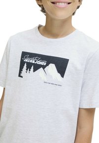 T-shirt en coton gris avec un imprimé graphique de montagnes et d'arbres en noir et blanc, accompagné du texte "Essential Jack & Jones".