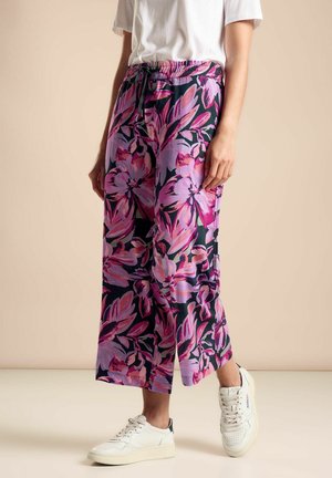 Blommiga byxor med vida ben och en mörk bakgrund som har stora rosa och lila blommor. Elastisk midja med snörning för anpassad passform.