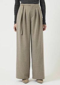 Pantaloni a gamba larga in tessuto grigio chiaro con una texture sottile. Presentano pieghe frontali, chiusura laterale con bottoni e dettaglio in vita con laccio.