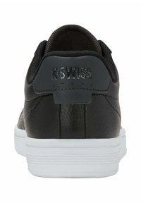 Černé kožené tenisky s texturovaným svrškem, bílou gumovou podrážkou a logem K-Swiss na patě. Klasický nízký design.