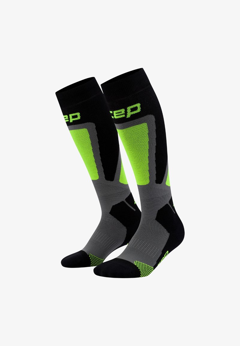 Calzini compressivi sportivi neri e grigi con accenti verde neon, caratterizzati da una texture a coste e aree del dito e del tallone rinforzate.