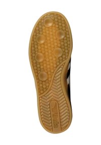 Suela de un zapato de goma beige, con un agarre texturizado que presenta seis almohadillas circulares y un patrón en zigzag, marcada con "Veda".