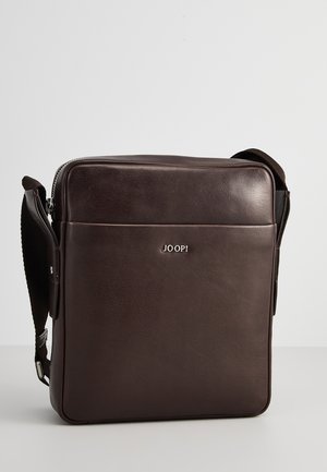 Brązowa skórzana torba na ramię o gładkiej teksturze, prostokątnym kształcie, regulowanym pasku oraz srebrnym logo "JOOP!" z przodu.