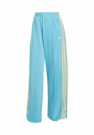 Pantaloni della tuta azzurro chiaro in tessuto morbido, con vestibilità comoda, strisce gialle sui lati e logo Adidas sul davanti.