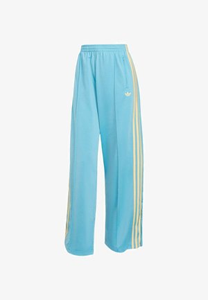 Pantaloni della tuta azzurro chiaro in tessuto morbido, con vestibilità comoda, strisce gialle sui lati e logo Adidas sul davanti.