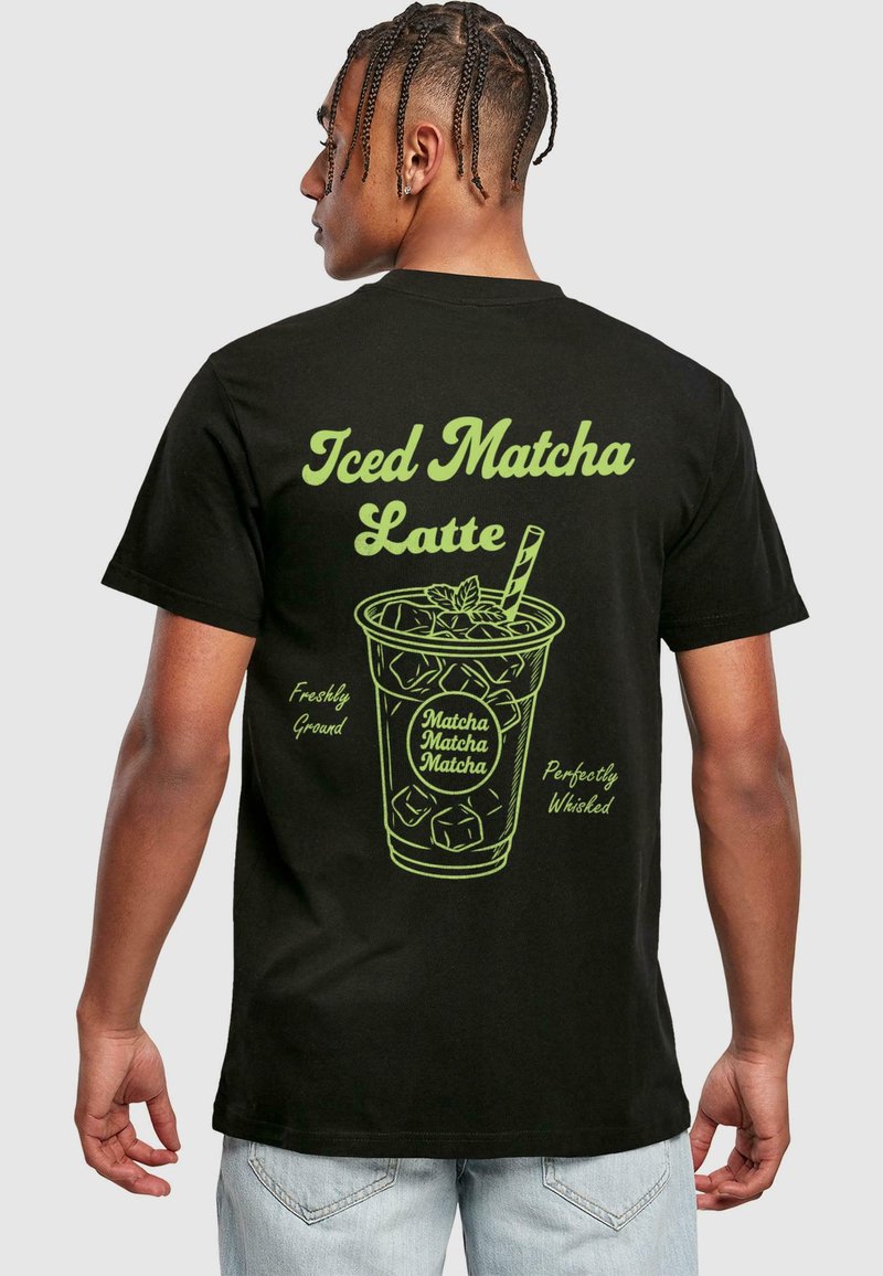 Black t-shirt featuring a green graphic of an iced matcha latte with text: "Iced Matcha Latte," "Freshly Ground," and "Perfectly Whisked."