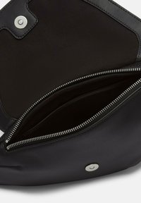 Czarna skórzana torba wewnątrz z gładką fakturą, zasuwaną kieszonką oraz zapięciem na magnes. Podszewka w jednolitym ciemnym kolorze.