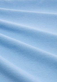Tejido azul claro con una textura suave, que presenta pliegues que fluyen suavemente y un color uniforme en toda su extensión.