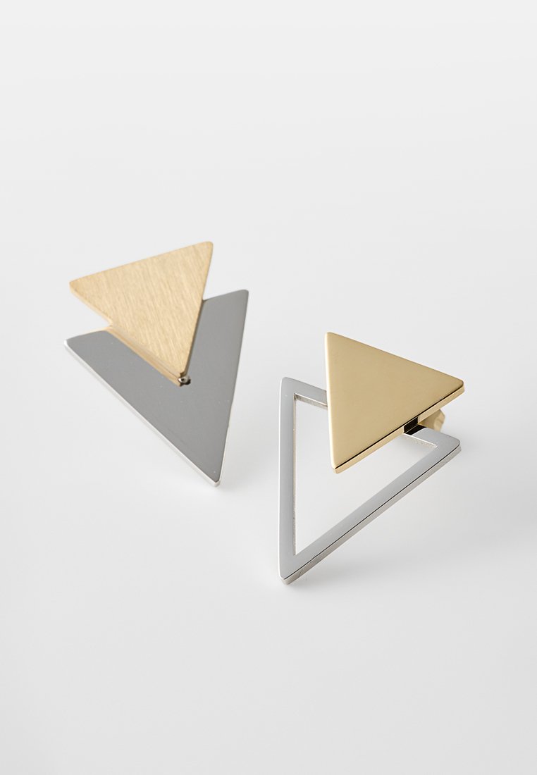 Geometrische Ohrringe mit zwei überlappenden dreieckigen Formen, eine aus goldfarbigem gebürstetem Metall und die andere in glänzendem silberfarbenem Finish.