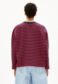Rood en marineblauw gestreept langemouwen t-shirt, met een ronde hals en een relaxte pasvorm. Zachte stof met zichtbare stikseldetails op de naden.