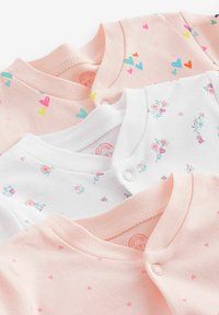 Tre babydragter: en lys pink med farverige hjerter, en hvid med små blomster mønstre, og en anden lys pink med små hjerter.