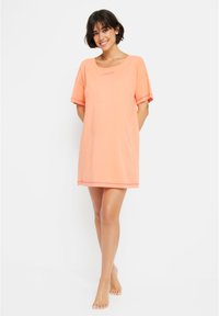 Orange t-shirt dress with a scoop neck and short sleeves. The hem features a slight trim. Made of soft material for comfort.