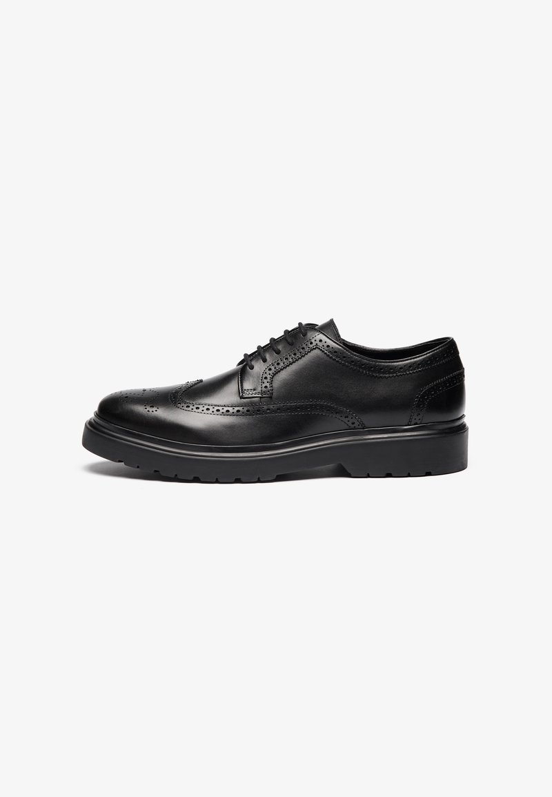 Chaussure habillée en cuir noir avec des détails brogue, bout arrondi et semelle en caoutchouc robuste. Présente un système de laçage et une finition lisse.
