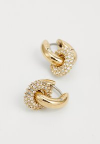 Boucles d'oreilles en métal doré avec un design texturé agrémenté de grappes de strass transparents, créant un look scintillant et complexe.