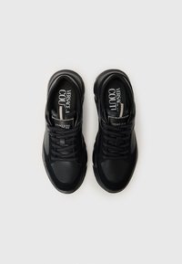 Svarte atletiske joggesko med teksturert skinn og mesh, med snøring, polstret krage og trykte logoakenter på innersålen.