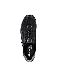 Zwarte sneaker met glanzende en textuurrijke panelen, veterluiting aan de voorkant, zijrits en logo op de inlegzool en tonglabel.