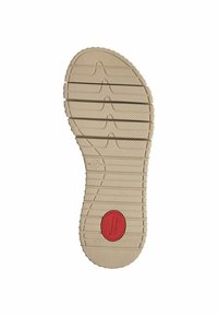 Semelle de chaussure en caoutchouc beige avec surface texturée. Présente des rainures horizontales et un logo circulaire rouge marqué "Confort". Design à bout rond.