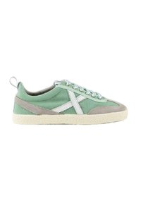 Zapatillas de lona verdes con detalles de ante gris, cordones blancos, suela blanca texturada y un distintivo diseño de 'X' blanca en el lateral.