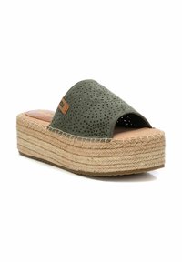 Sandalia de diapositiva verde perforada con punta abierta, suela de cuña de yute y goma, y un acento de logo en tono marrón. Presenta un diseño superior texturizado.