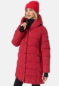 Red puffer coat with a hood, featuring a quilted design, black accents, side pockets, and button closures. Paired with a matching beanie.