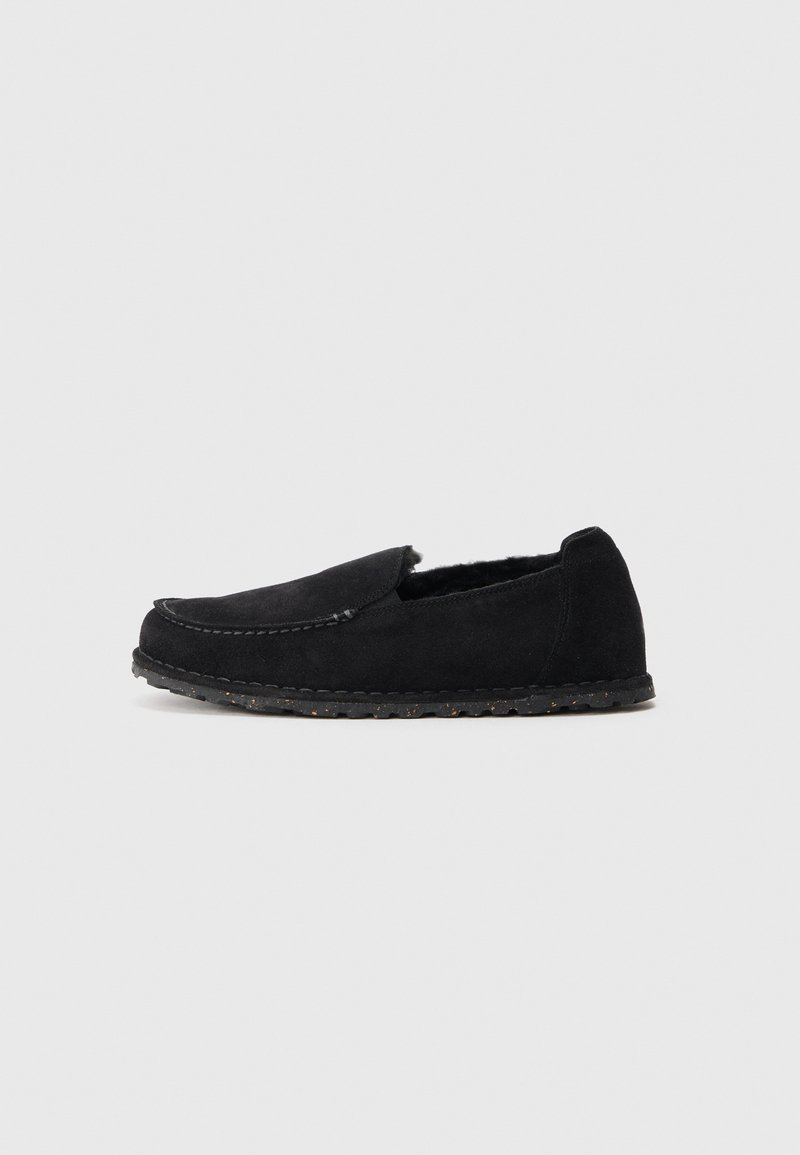 Fekete velúr slip-on cipők lekerekített orral, texturált külsővel és kis tapadási pontokkal ellátott gumitalppal. Nincs látható fém alkalmazás.