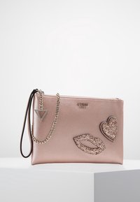 Clutch-Tasche in Roségold aus strukturiertem synthetischem Material, mit dekorativen Glitzerlippen- und Herz-Patches, silbernen Akzenten und Kettenriemen.