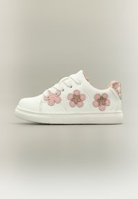 Άσπρο αθλητικό παπούτσι με τρία ροζ διακοσμητικά λουλούδια, λαμπερή ροζ λεπτομέρεια στη φτέρνα, επίπεδη καουτσούκ σόλα και στρογγυλή μύτη.