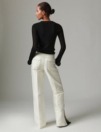 Μαύρο κορμάκι μακρυμάνικο ριμπ, σε συνδυασμό με λευκό παντελόνι με επίπεδο μπροστινό μέρος, διπλές πίσω τσέπες, αντίθετη ραφή και πλαϊνές σχισμές.