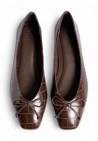 Ballerines synthétiques marron avec une texture crocodile, présentant un détail en nœud à l'avant et une semelle intérieure lisse légèrement rembourrée.