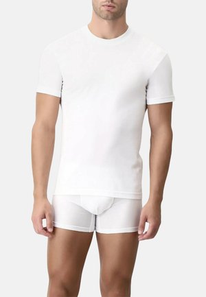 Maglietta bianca a maniche corte realizzata in tessuto liscio, abbinata a slip bianchi attillati. Entrambi presentano un design elegante e minimalista.