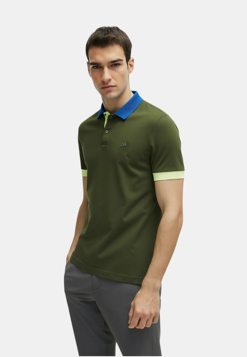 Polo shirt verde a maniche corte con colletto blu e dettagli verde lime. Presenta un logo discreto sul petto e una vestibilità classica.