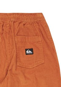 Brända orangea kordshorts med elastisk midja, med en bakficka och en liten svart och vit Quiksilver-logotyp.