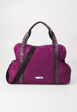 Paarse nylon sporttas met dubbele handvatten en een lange verstelbare schouderband. Kenmerkt logo-accenten op de banden en een gladde, duurzame textuur.