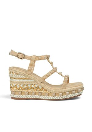 Wedge sandal in light beige with strappy design. Features woven details on the sole and a buckle closure. Soft textured materials.