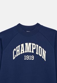 Ναυτικό μπλε φούτερ με ραμμένο λαιμό, με έντονο λευκό κείμενο "CHAMPION" καμπυλωτό πάνω από το "1919" στο στήθος.