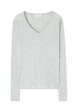 Siva majica dugih rukava s V-izrezom, napravljena od mekanog materijala, s opuštenim krojem i bočnim prorezima. Jednostavan i svestran dizajn.