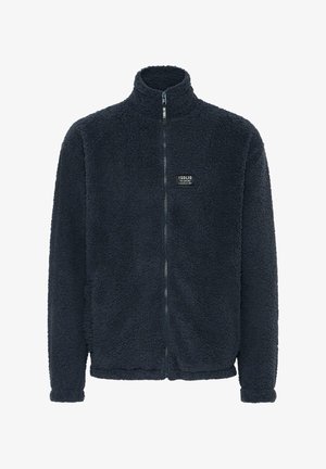 Sötét tengerészkék polárdzseki, magas nyakkal, teljes zippel, texturált felülettel, és egy kis fekete márkajelzéssel a mellkason.