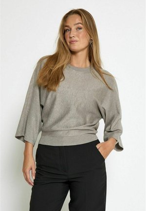 Gray, lightweight sweater with a crew neck, loose sleeves, and ribbed hem. Worn with black trousers, displaying a relaxed fit and smooth texture.