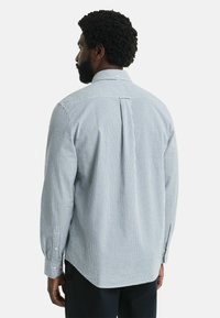 Blaue und weiße karierten Hemd mit langen �Ärmeln, Knopfmanschetten und einer Rückenfalte. Aus Baumwollmaterial mit lockerer Passform.