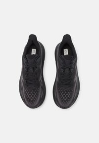 Scarpe sportive nere con parte superiore in mesh testurizzato con un motivo a diamante, lacci rotondi e suola imbottita per supporto.