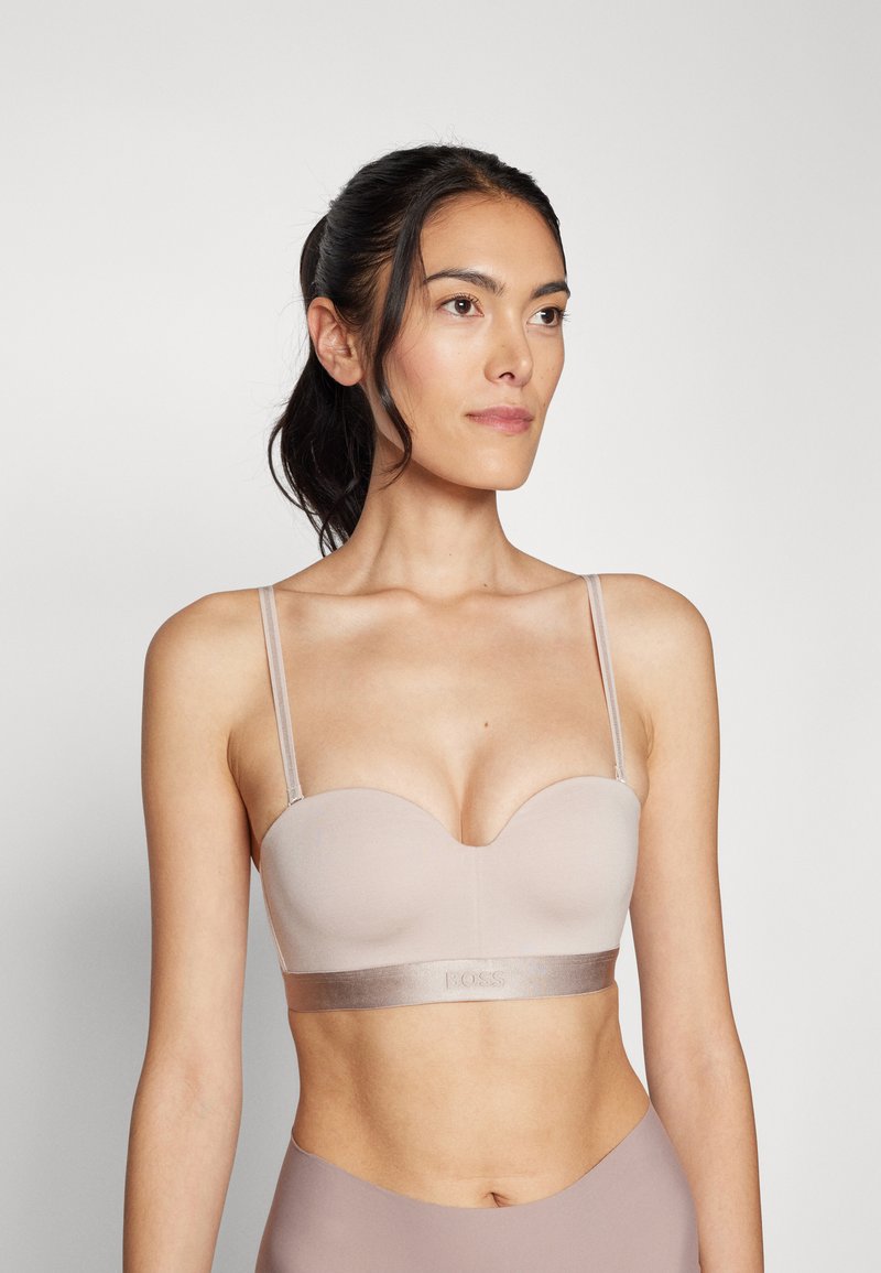Blød, nude-farvet bralette med sweetheart-udskæring, tynde justerbare stropper og et satinbånd med prægede detaljer.