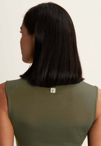 Top sans manches vert olive avec une texture lisse, arborant une petite étiquette logo au dos du col et une silhouette ajustée.