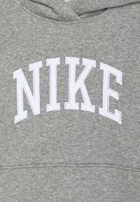 Sudadera gris con un logo bordado en blanco "NIKE" en el pecho, con una textura suave y un diseño de capucha estándar.